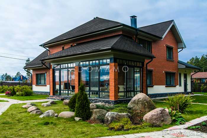 Проект каркасного дома с просторной верандой, гаражом и навесом для авто