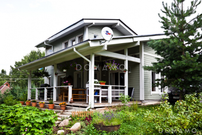 Проект дома из пеноблоков с навесом для машины и двумя спальнями на мансардном этаже